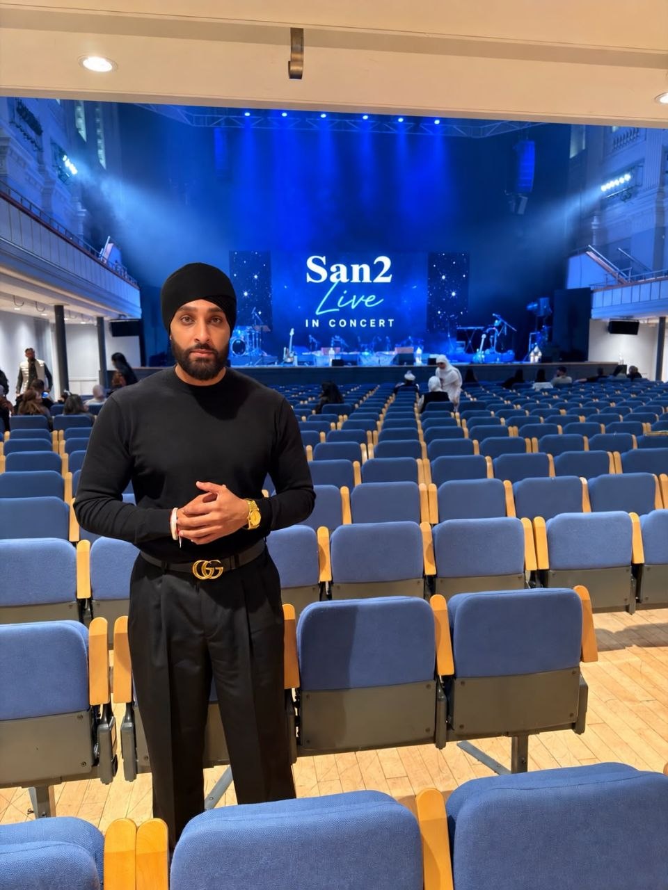 San2 in a concert hall with San2 Live on the stage screen