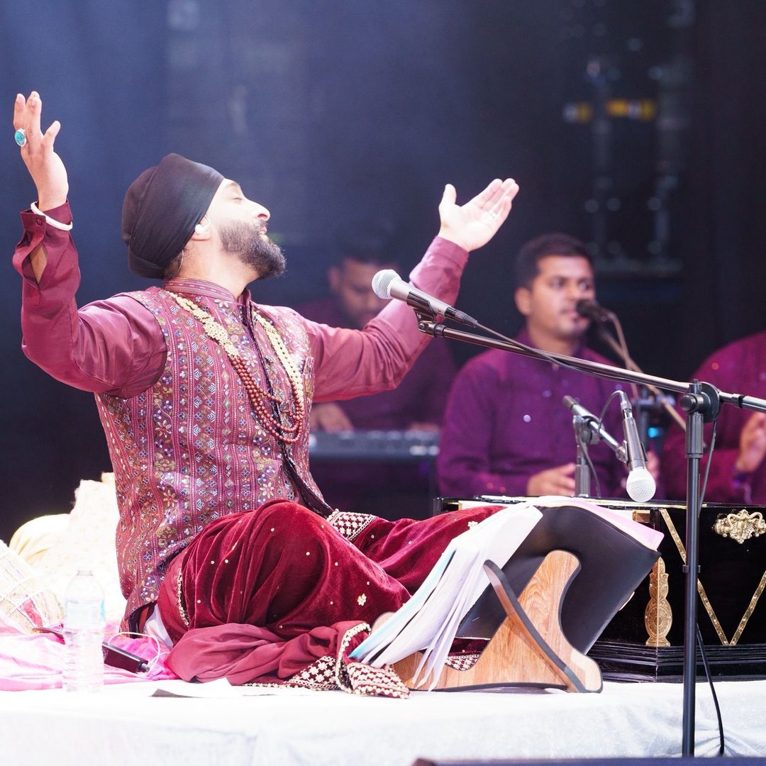 San2 performing at the harmonium on stage